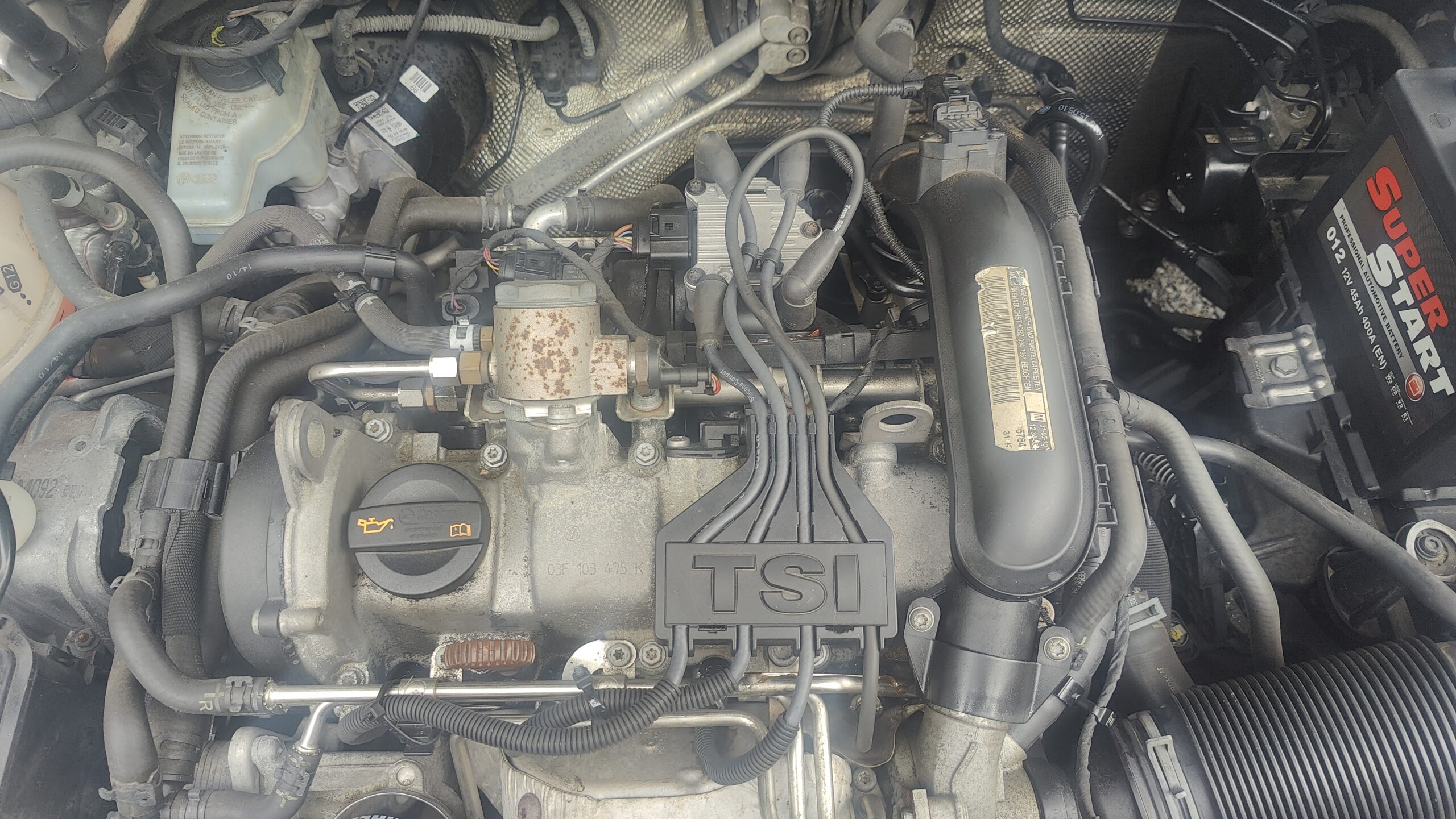 Engine bay as it arrived in the workshop. New ignition coil and plug leads, although one doesn't fit correctly as it was changed by the customer.